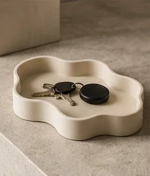 Ivory tray with a flowing edge, holding keys and small objects.
